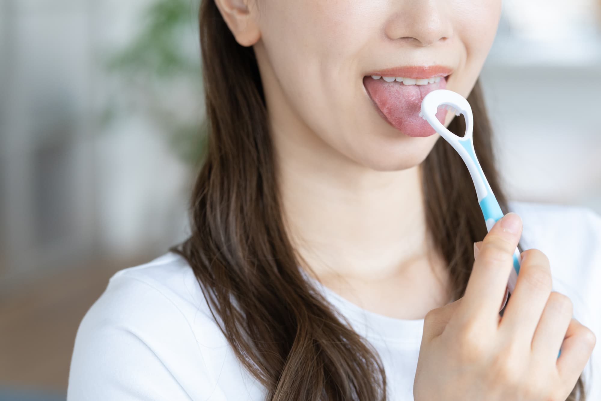 口臭対策で舌の清掃をする女性