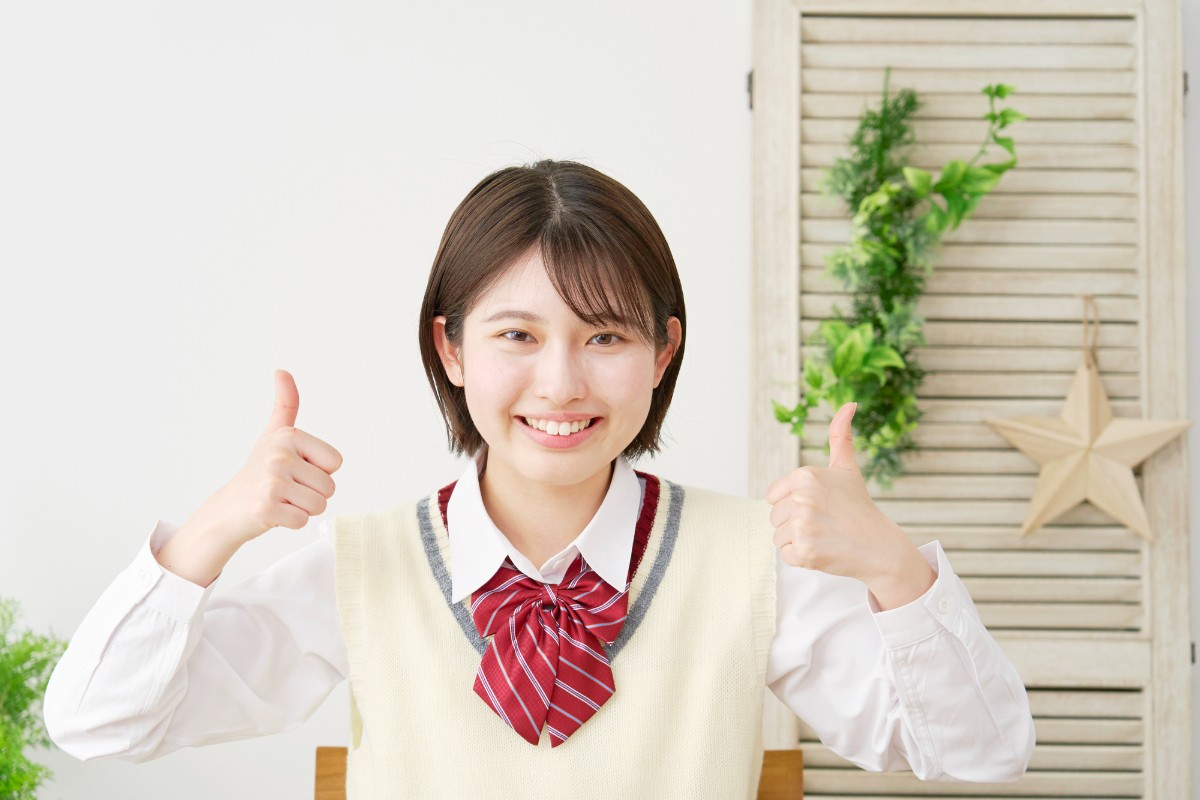 小児矯正が終わってグッドサインをする女子高生