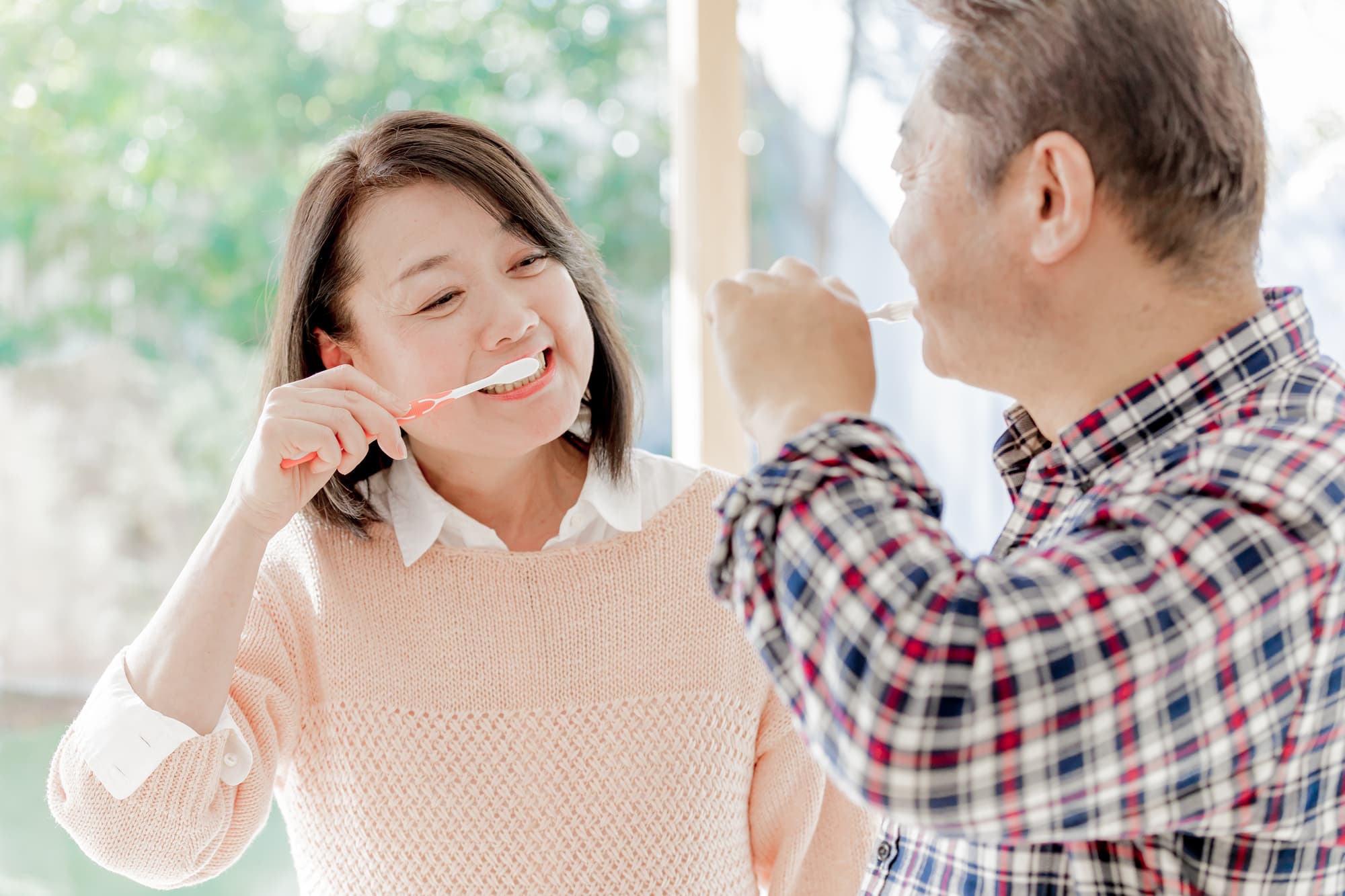 仲良く歯磨きをして虫歯を予防する夫婦