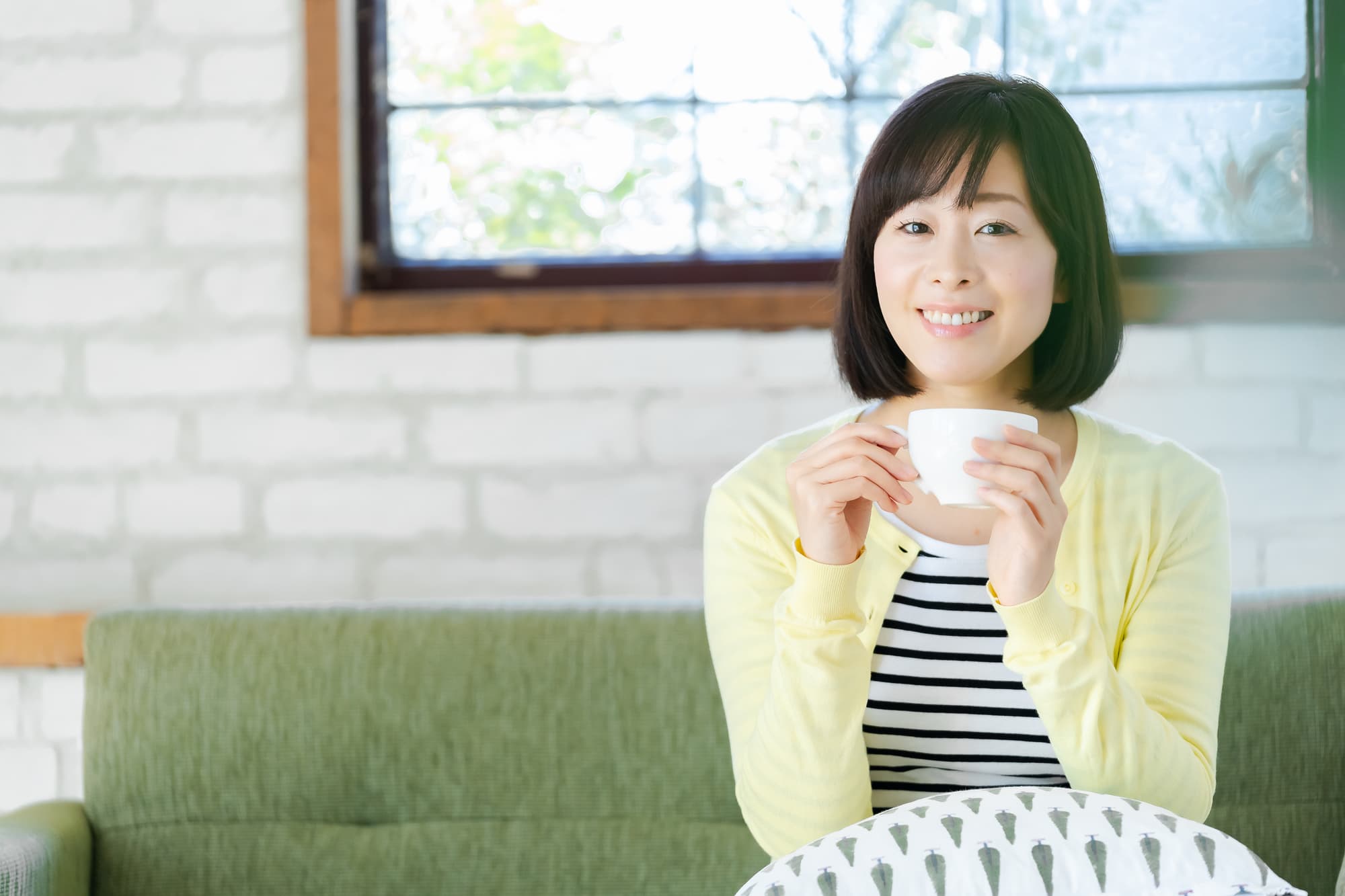 根管治療を終えて飲み物を楽しんでいる女性